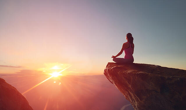 Frau sitzt auf einem Felsen 